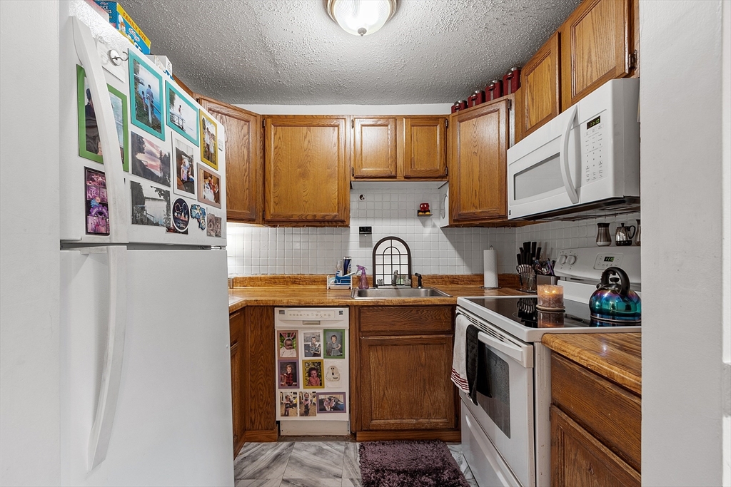 168 Ayer Road, Unit F3 Shirley, MA 01464 - Photo 8 of 36 a kitchen with stainless steel appliances granite countertop a sink a stove and cabinets