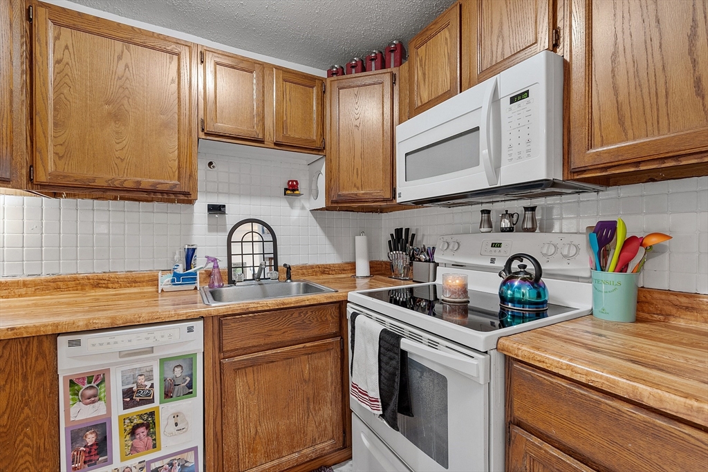 168 Ayer Road, Unit F3 Shirley, MA 01464 - Photo 9 of 36 a kitchen with stainless steel appliances granite countertop a sink stove and cabinets