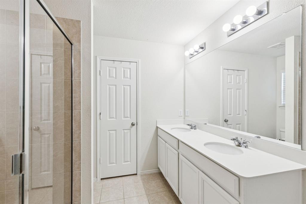 1207 Perrin Drive Forney, TX 75126 - Photo 14 of 20 a bathroom with a double vanity sink and a mirror