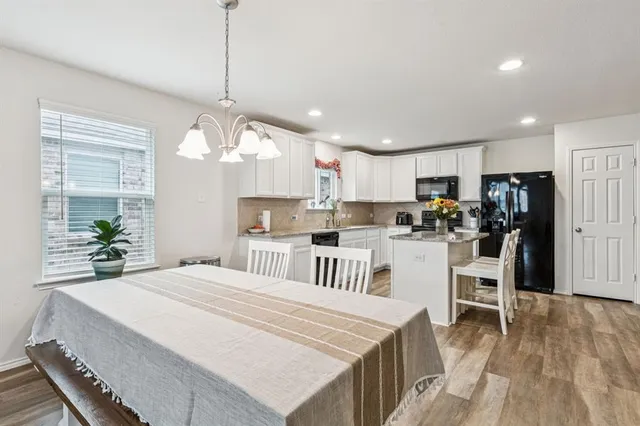 a kitchen with kitchen island a refrigerator a stove a center island and a wooden floor