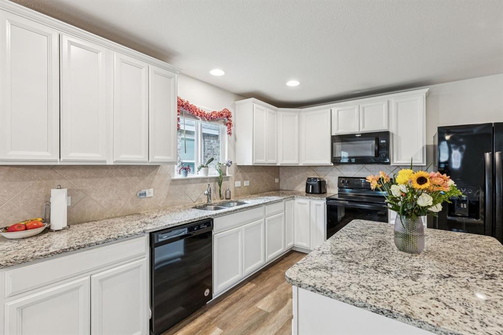 1207 Perrin Drive Forney, TX 75126 - Photo 5 of 20 a kitchen with stainless steel appliances granite countertop a sink a stove top oven a counter space and cabinets