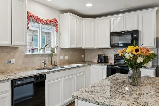 a kitchen with a sink a stove and cabinets
