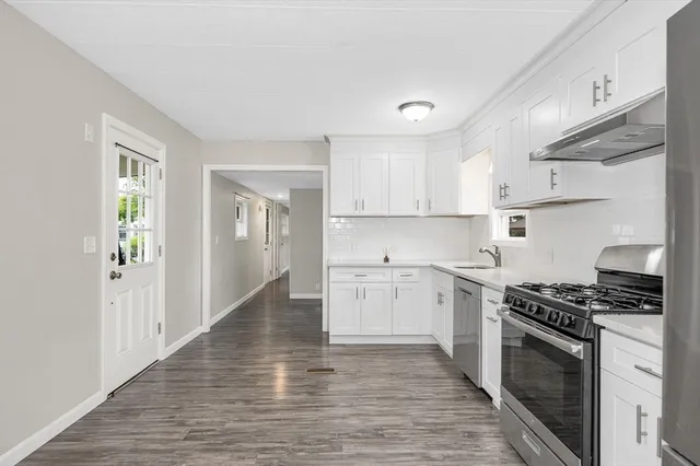 a kitchen with stove cabinets and wooden floor