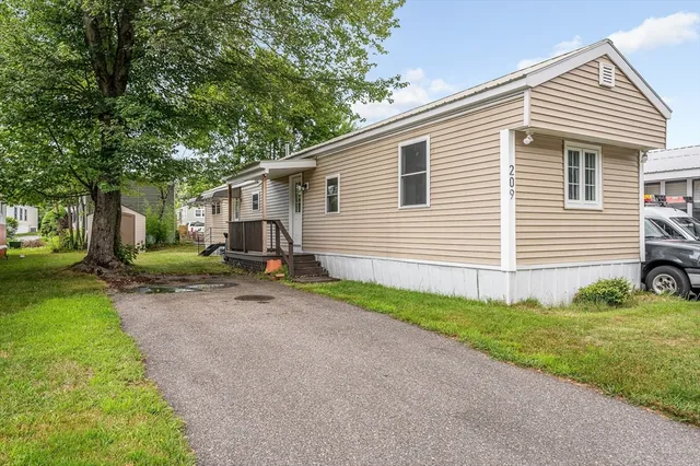 a small white house with a white roof and a yard