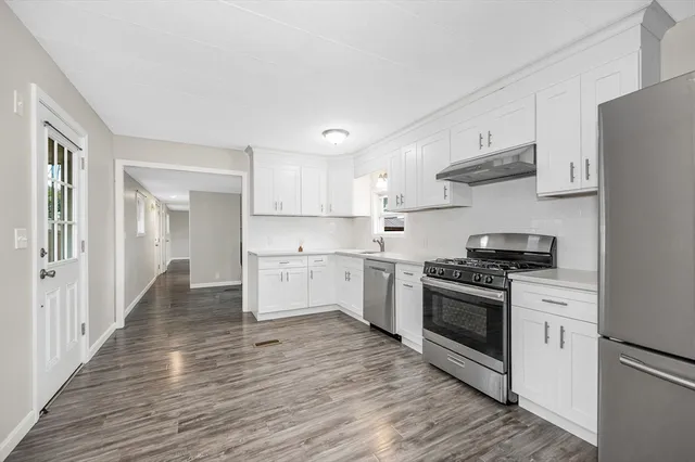 a kitchen with stainless steel appliances granite countertop a stove a sink and a refrigerator