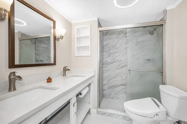 a bathroom with a sink toilet vanity and shower