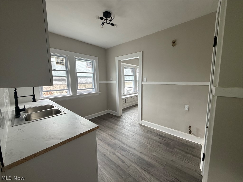 15317 Shiloh Road Cleveland, OH 44110 - Photo 14 of 29 Kitchen area featuring a double basin stainless steel sink with a matte black faucet, light-toned countertops, and grey wood-finish flooring