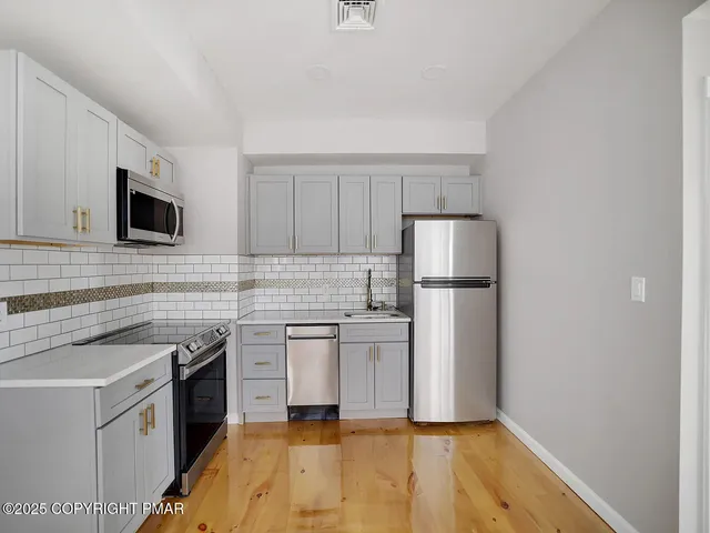 a kitchen with cabinets stainless steel appliances and a sink