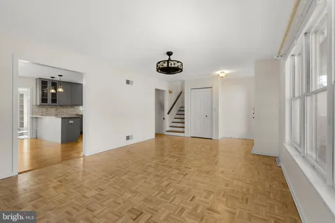 a view of empty room with wooden floor and a window