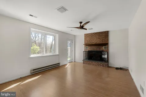 an empty room with windows and fireplace