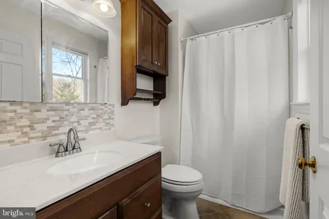 a bathroom with a sink a toilet and mirror