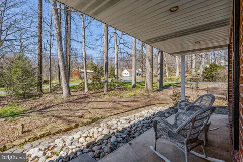 a view of a patio with table and chairs and floor to ceiling window