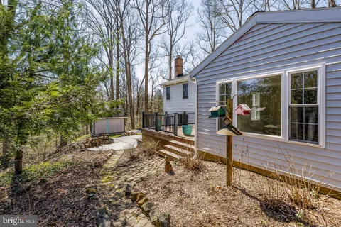 a view of a house with backyard and chairs