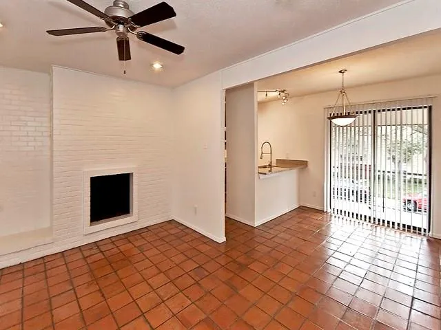 an empty room with windows and fireplace
