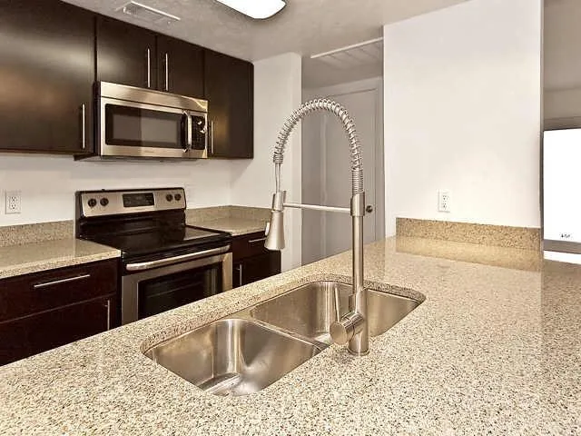 a kitchen with stainless steel appliances granite countertop a sink microwave and stove