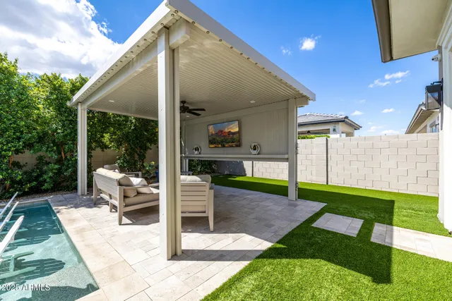 a view of a patio with couches chairs potted plants and a palm tree