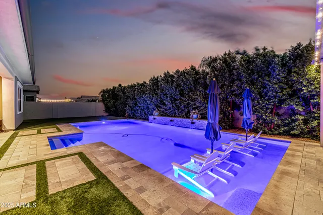 a view of swimming pool with red chairs and couches with wooden floor