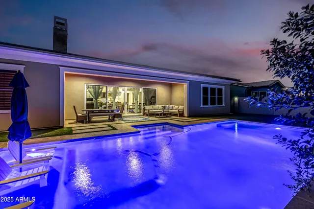 swimming pool with seating area and trees in the background