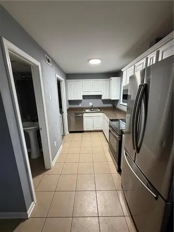 a kitchen with stainless steel appliances granite countertop a refrigerator and a stove