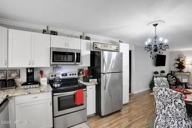 a kitchen with stainless steel appliances granite countertop a refrigerator a stove a microwave oven a sink with island and chairs