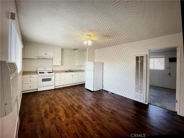 a kitchen with wooden floors and refrigerator