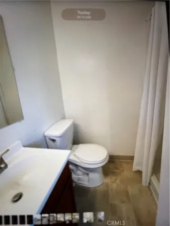 a white toilet sitting next to a white sink