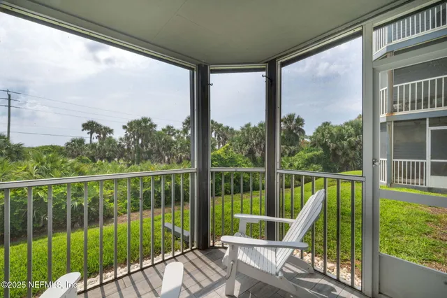 a view of a deck with a floor to ceiling window and wooden fence