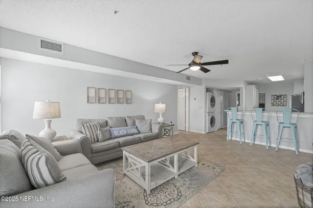 a living room with furniture and a ceiling fan