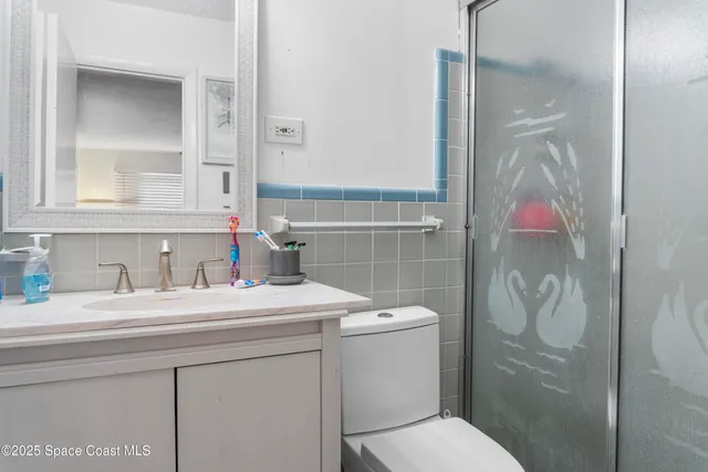 a bathroom with a sink vanity mirror and toilet