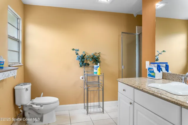 a bathroom with a granite countertop toilet and a sink