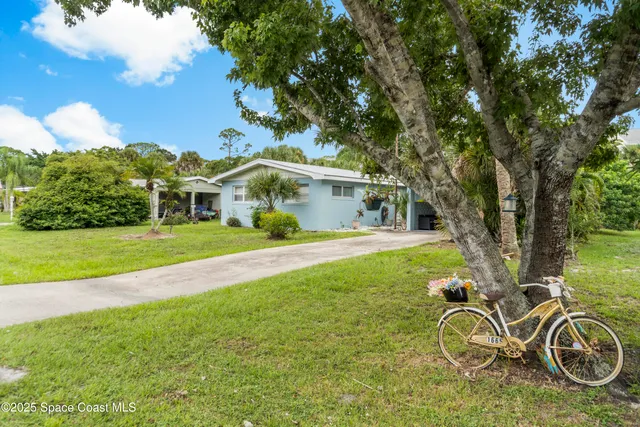 a view of a house with a yard table and chairs