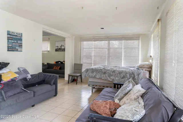 a bedroom with furniture and a large window