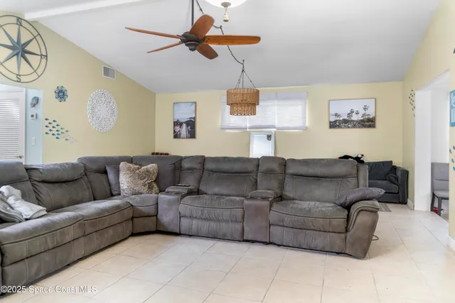 a living room with furniture and a ceiling fan