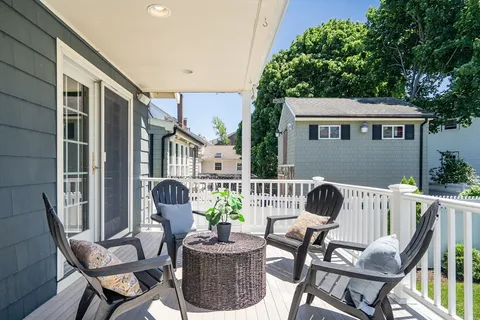 a view of a patio with table and chairs and a barbeque