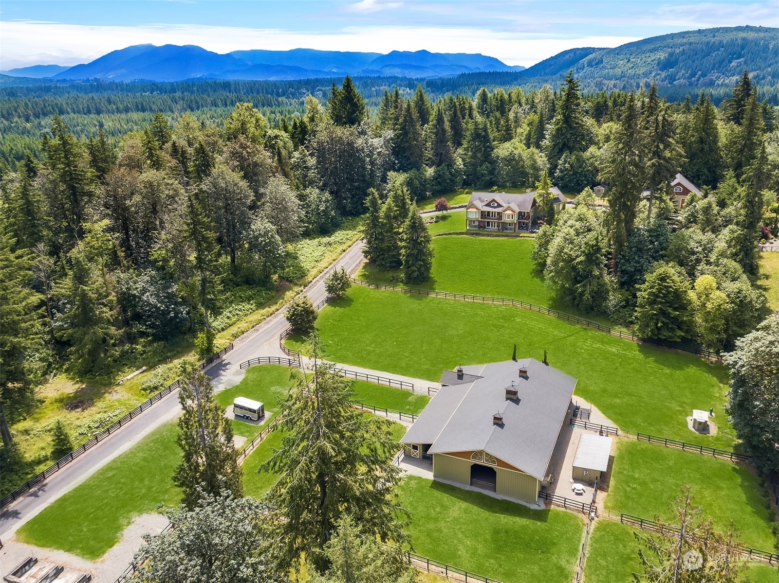 an aerial view of a house with a garden and lake view