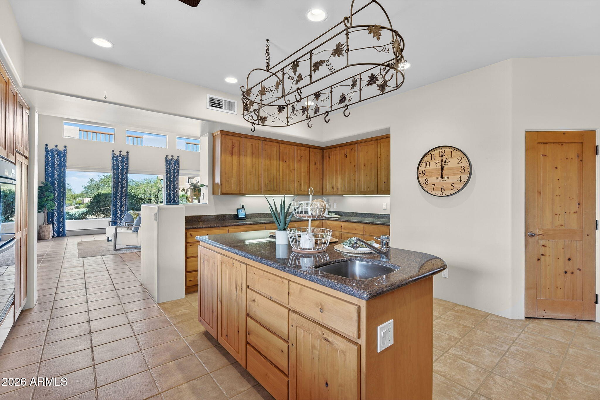 8540 East McDowell Road, Unit 110 Mesa, AZ 85207 - Photo 11 of 74 a kitchen with a counter space a clock and cabinets