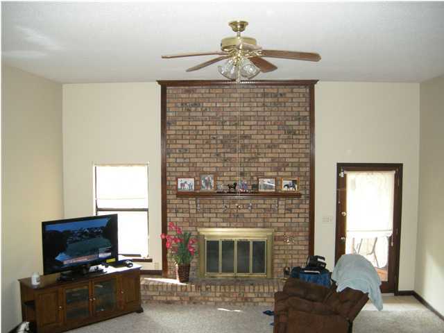 1083 Tallokas Road Crestview, FL 32536 - Photo 8 of 35 a living room with furniture a fireplace and a flat screen tv