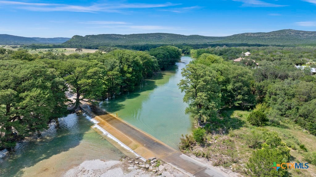 360 Bluebonnet Concan, TX 78838 - Photo 30 of 32 a view of a lake with a mountain in the background