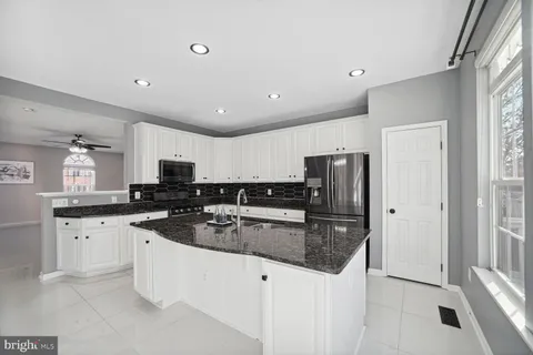 a kitchen with stainless steel appliances granite countertop a sink stove refrigerator and cabinets