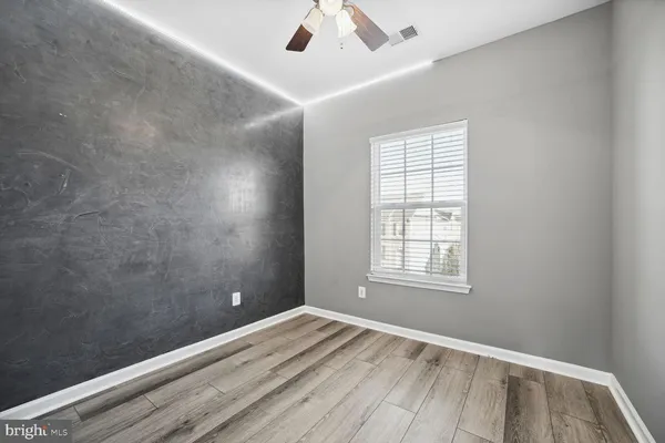 an empty room with a window and wooden floor