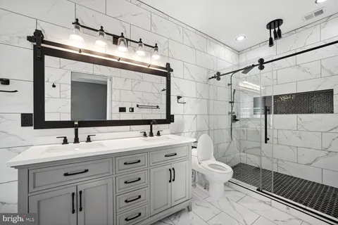 a bathroom with a double vanity sink mirror and toilet