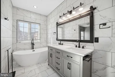a bathroom with a large tub sink and mirror