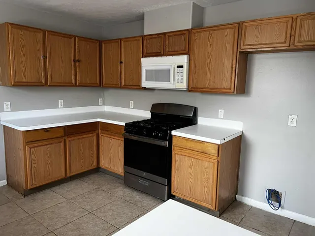a kitchen with stainless steel appliances granite countertop a sink stove and microwave