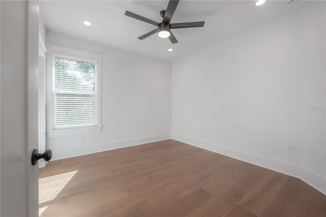 an empty room with a window and a fan