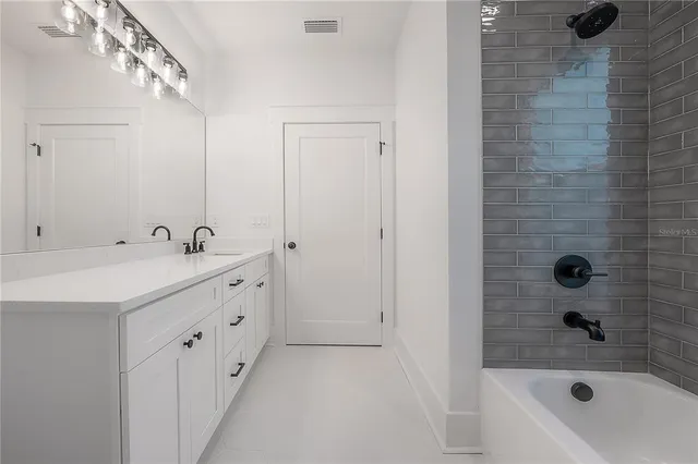 a bathroom with a tub sink shower and mirror