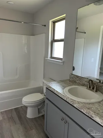 a bathroom with a granite countertop sink a toilet and a bathtub