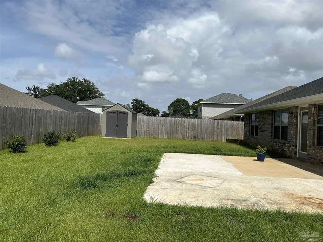 a view of a house with backyard and sitting area
