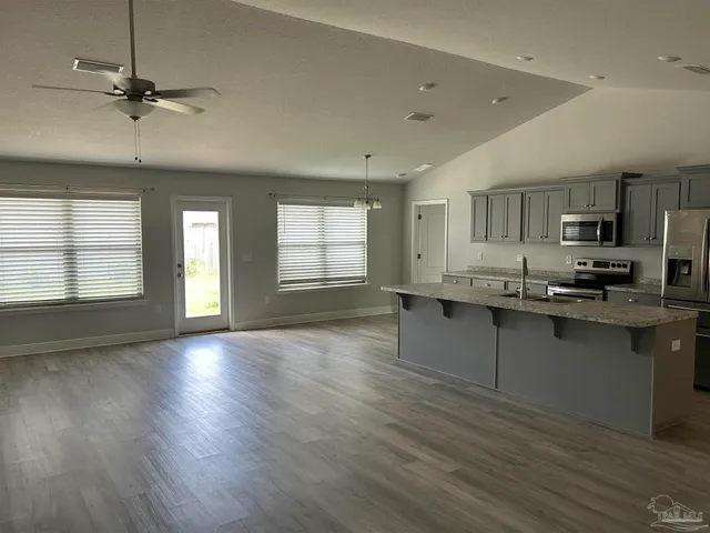 a view of a kitchen with a sink cabinets and wooden floor