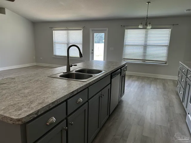 a kitchen with a sink and wooden floor