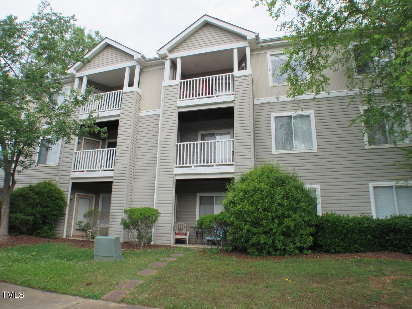 1401 Collegiate Circle, Unit 104 Raleigh, NC 27606 - Photo 1 of 29 a front view of a house with a yard and garage